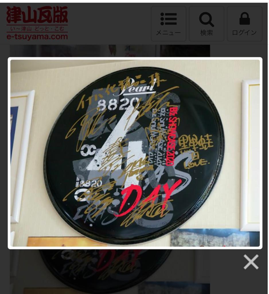 B'zのバンドメンバーのサインが入った配信ライブ「Day4」のドラムヘッドの写真