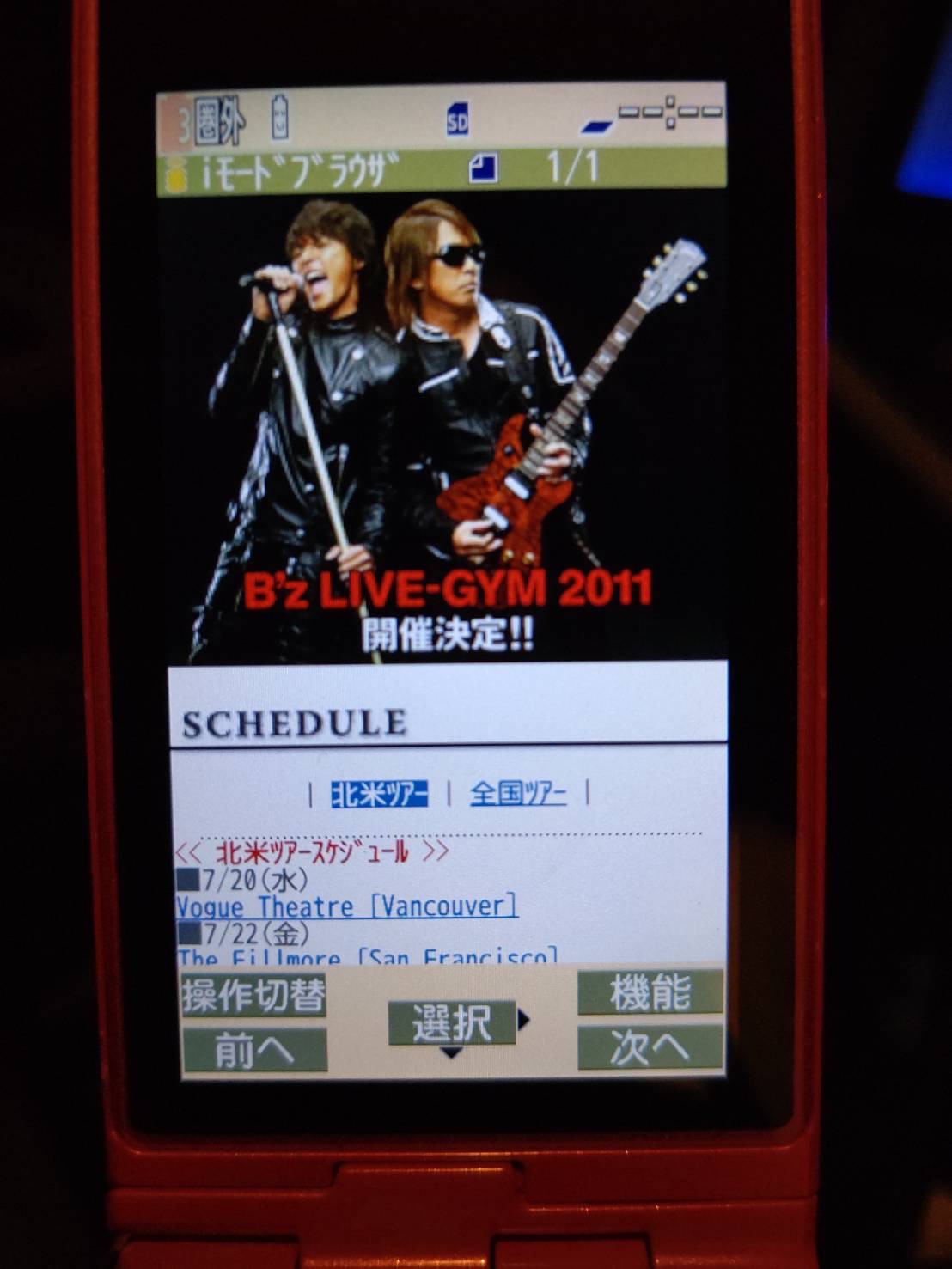 「B'z LIVE-GYM 2011」開催決定ニュースをガラケーで表示している様子の画像