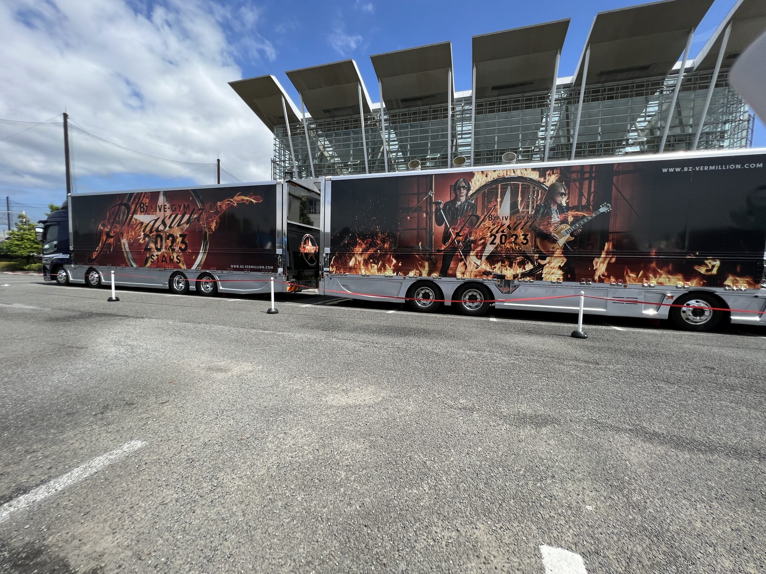 『B'z LIVE-GYM Pleasure 2023 -STARS-』のツアートラックが縦列駐車している写真