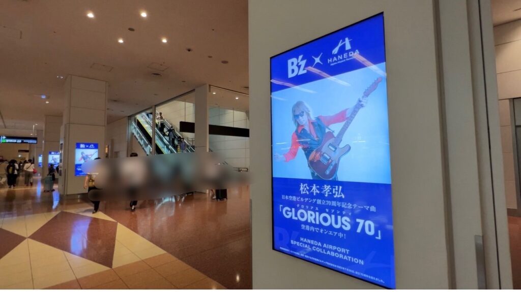 「B'zデビュー35周年 × 日本空港ビルデング創立70周年」の柱のサイネージ広告